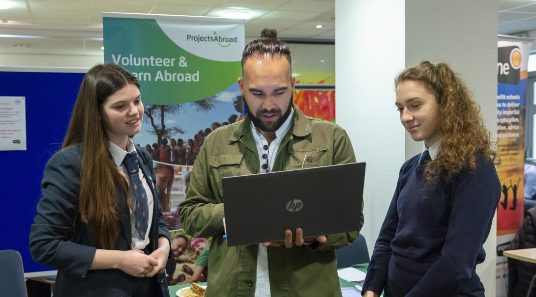 Leads have the volunteer projects and internships explained during an event. Projects Abroad staff talk to potential volunteers during an information event in the UK.